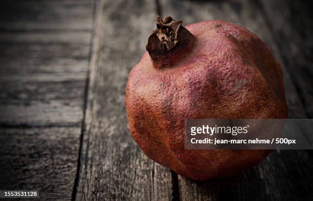 close-up of pomegranate on table,london borough of ealing,united kingdom,uk - stone crop plant stock pictures, royalty-free photos & images