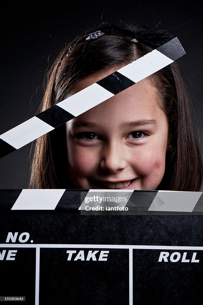 Happy child with movie clapper board.