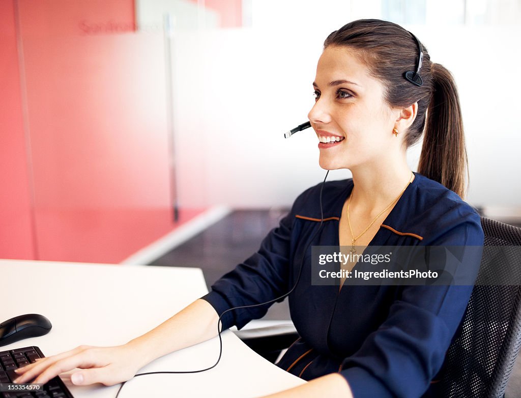 Young beautiful woman at her workplace in the office.