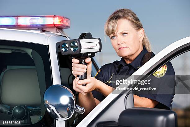 traffic enforcement: woman police officer with laser gun - highway patrol stock pictures, royalty-free photos & images