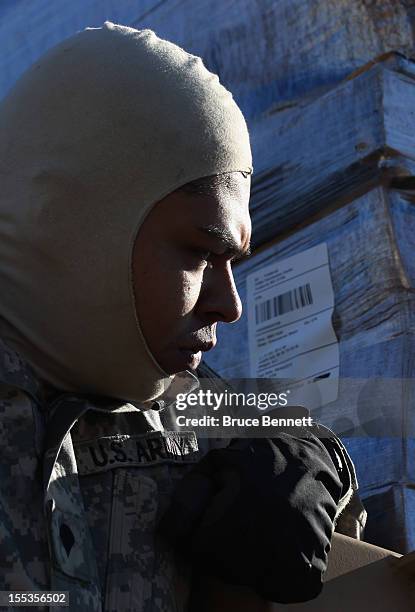 Army soldier Carlos Cuellar of Queens, New York prepares to drive food from the Federal Emergency Management Agency to affected areas of Long Island...