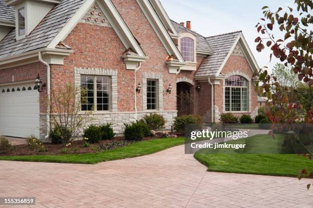 lovely red brick upscale home with concrete driveway. - large grass area stock pictures, royalty-free photos & images