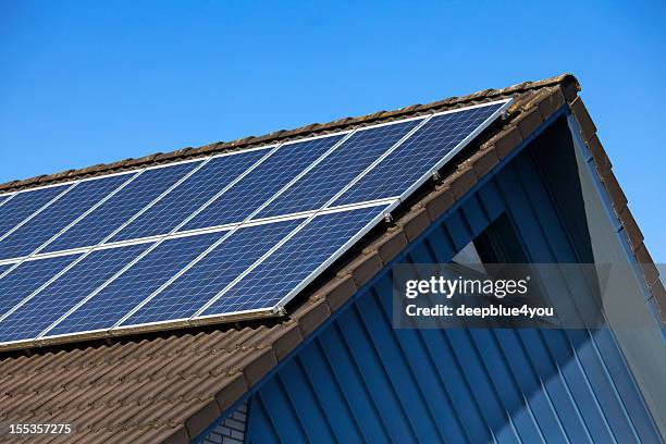 panel solar en techo gable contra el cielo azul - tejado fotografías e imágenes de stock