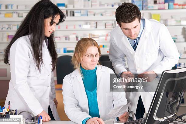 three pharmaceutical professionals on the computer - assistant professor stock pictures, royalty-free photos & images