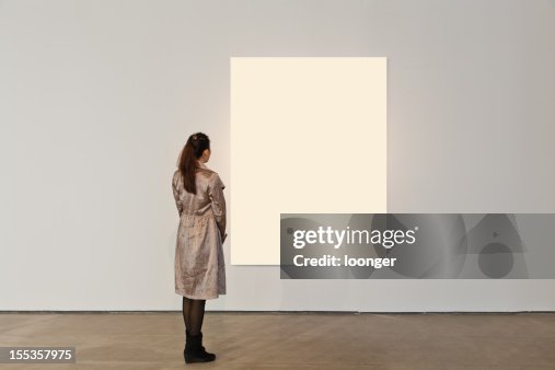 Eine Frau, die auf weißen Rahmen in Kunstgalerie Eine Frau, die auf weißen Rahmen in Kunstgalerie