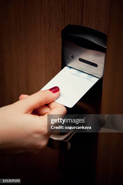 weibliche hand hineinstecken den zimmerschlüssel in türschloss hotel zimmer - hotelzimmer tür stock-fotos und bilder