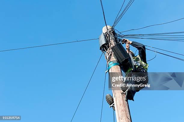 man on telegraph pole - utility pole stock pictures, royalty-free photos & images