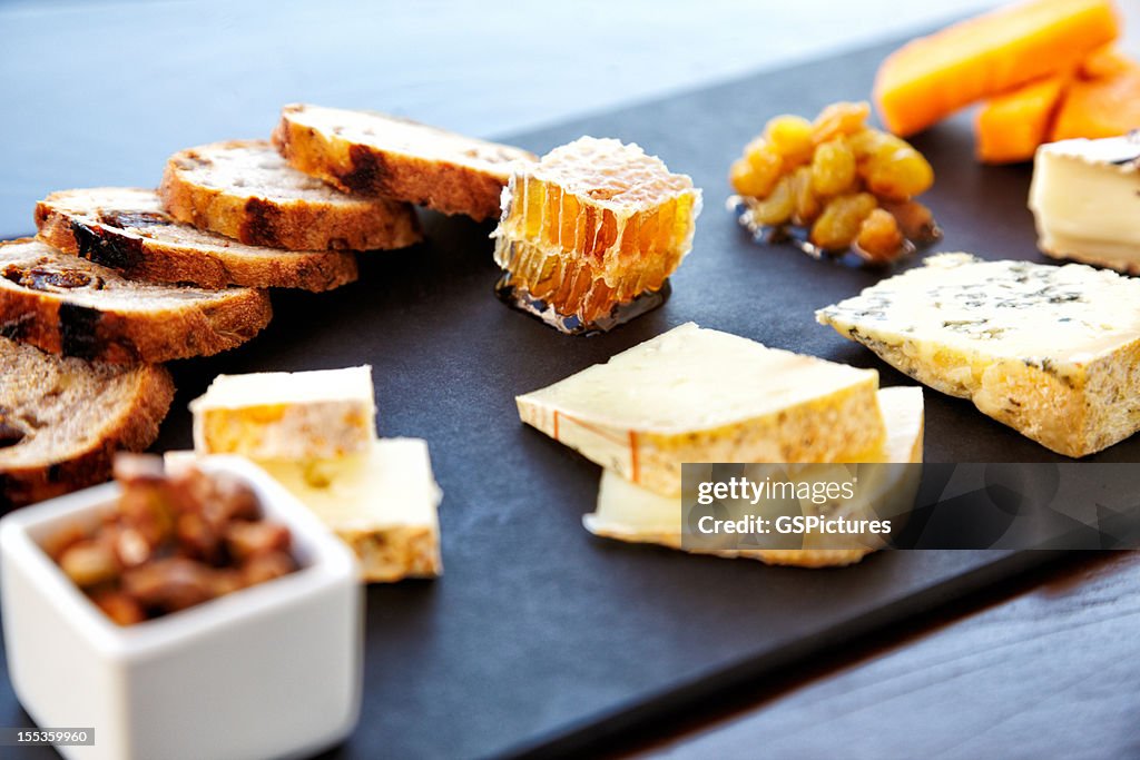 Fancy cheese plate with bread and honey