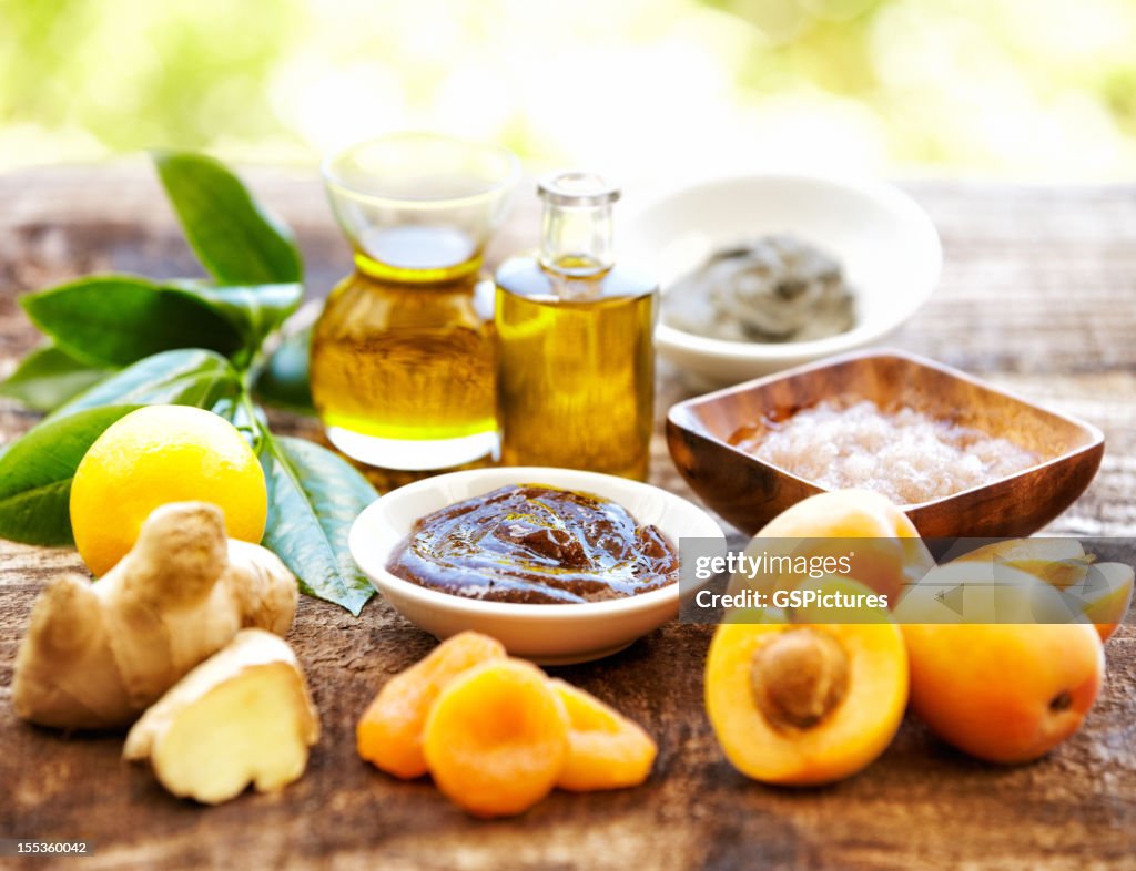 Spa still life with organic scrub, massage oil, apricots, ginger