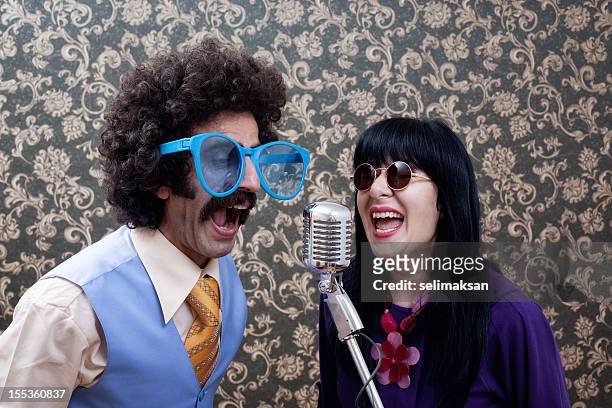 zwei freunde singen im seventies-stil mit alten mikrofon - silly band stock-fotos und bilder
