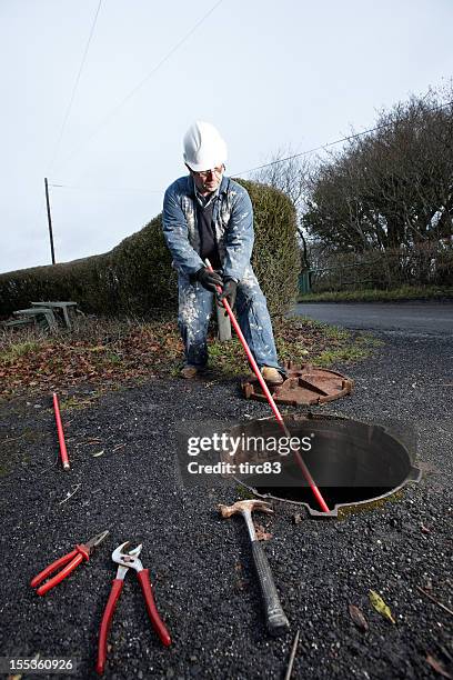 man clearing the drains - cesspit stock pictures, royalty-free photos & images