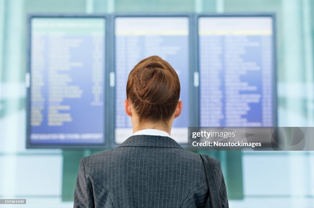 女性を探している空港での航空便の情報