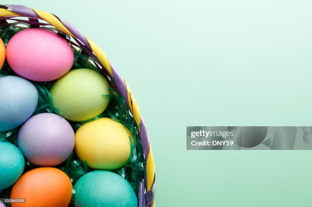 Easter eggs in Easter basket on green background