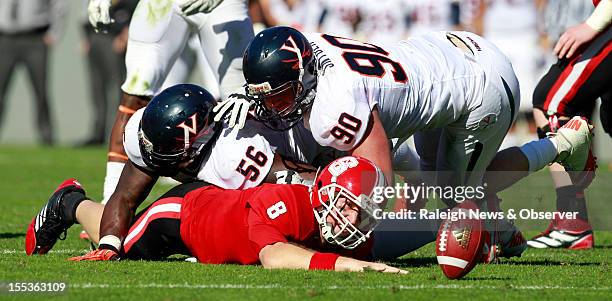 State quarterback Mike Glennon fumbles the ball after being sacked by Virginia defensive tackle Chris Brathwaite and defensive end Jake Snyder during...