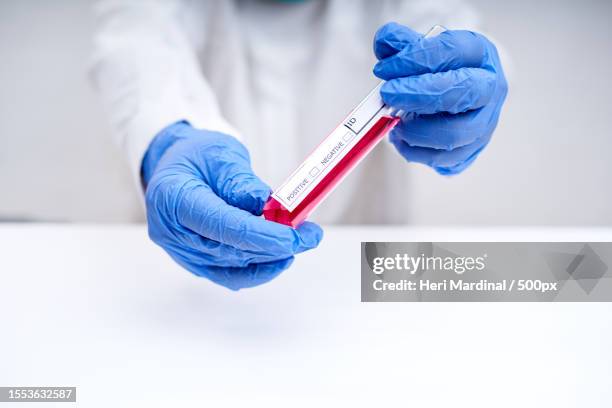 midsection of scientist holding test tube - heri mardinal stock pictures, royalty-free photos & images