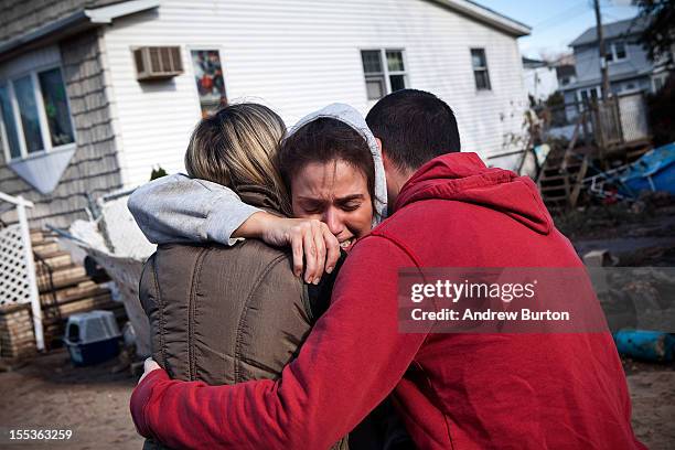 Doctor Rosanna Troia is consoled by volunteers while helping clean out her mother's home in the Midland Beach neighborhood of Staten Island on...