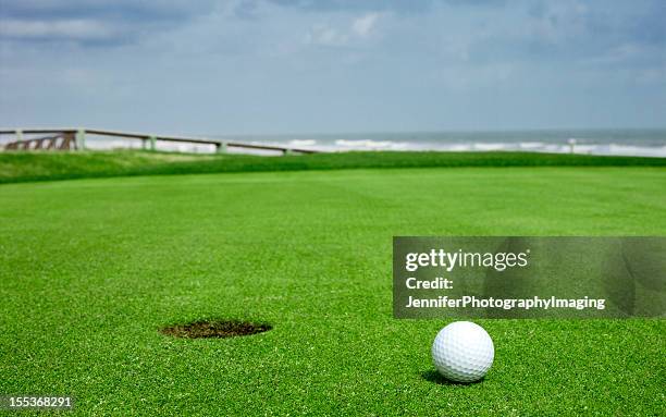 golf ball on green close to the hole - amelia island stock pictures, royalty-free photos & images