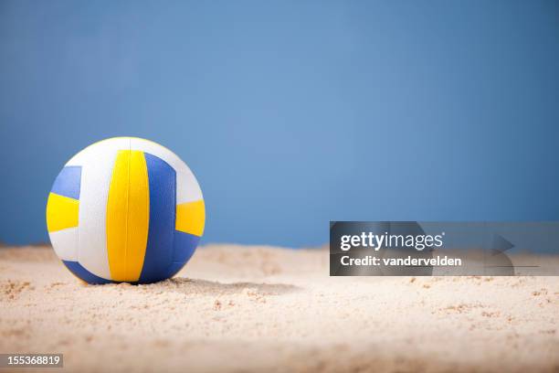 blue white and yellow volleyball on beach with copy space - beach volleyball stockfoto's en -beelden