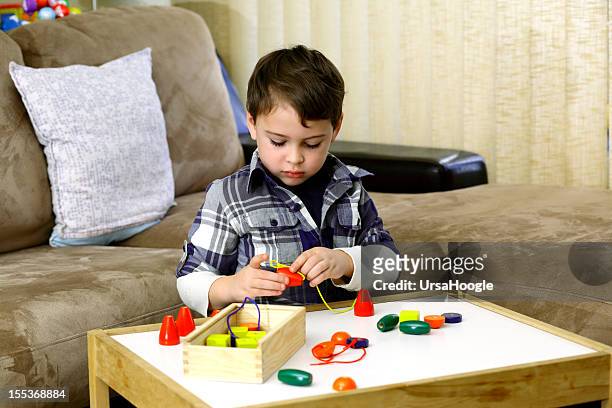 autista menino brincando com de madeira colorida contas - autism - fotografias e filmes do acervo