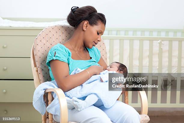 mother breastfeeding  her infant. - birthing chair stock pictures, royalty-free photos & images