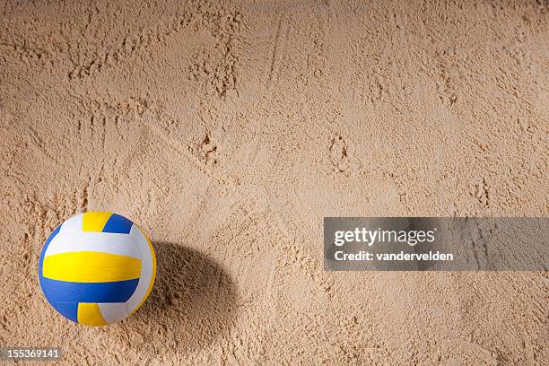 beach volleyball sitting on the sand - beach volleyball stockfoto's en -beelden