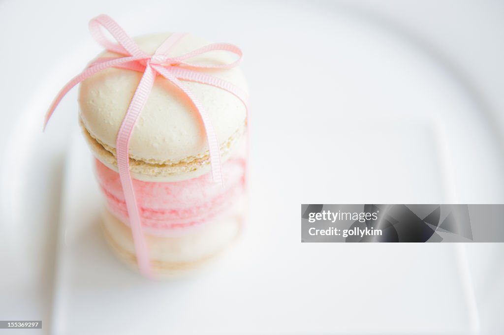 Macaroons with ribbon on white plate