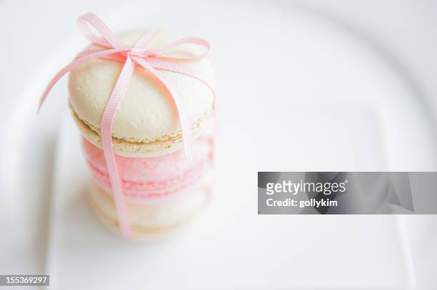 macaroons with ribbon on white plate - macaroon stock pictures, royalty-free photos & images