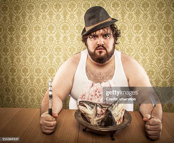 gran barbudo comiendo plato de pescado, undershirt cabezales - gross food fotografías e imágenes de stock