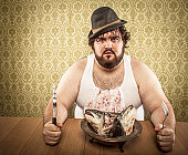 Large Bearded Man Eating Bowl of Fish Heads, Undershirt