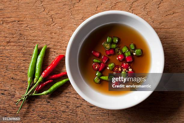 thai red and green chili in bowl of fish sauce. - nuoc cham stock pictures, royalty-free photos & images