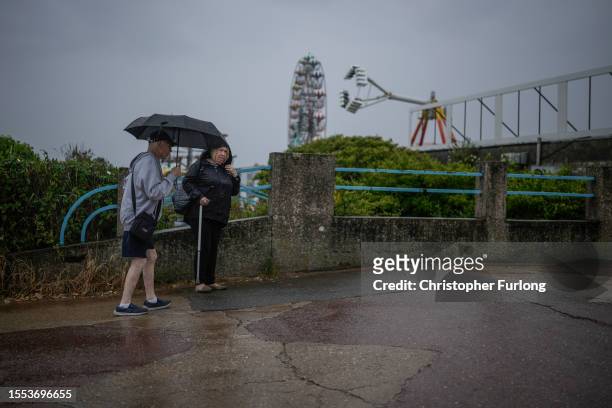 Holidaymakers brave a downpour on Skegness promenade on July 18, 2023 in Skegness, England. As wildfires and a heatwave grip most of Europe the...