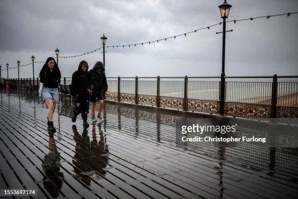 Holidaymakers brave a downpour on Skegness Pier on July 18, 2023 in Skegness, England. As wildfires and a heatwave grip most of Europe the inclement...