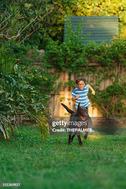 kid running with his dog - boy running with dog stock pictures, royalty-free photos & images