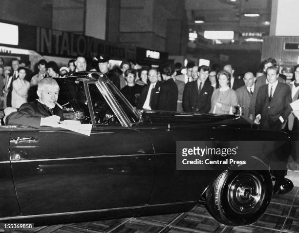 English disc jockey and television presenter Jimmy Savile buys a new Rolls Royce Silver Cloud III Drop Head Coupe at the Motor Show in Earl's Court,...