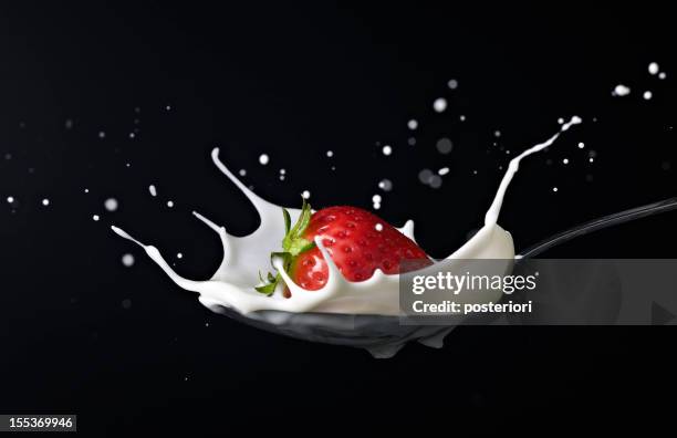 strawberry planschen in löffel voll milch - cream splash stock-fotos und bilder