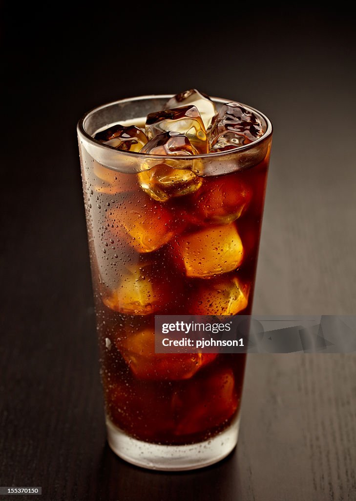 A glass full of iced coffee on a table