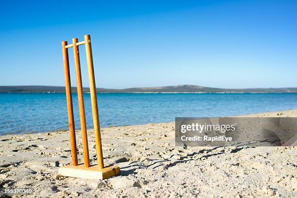 practise cricket stumps on beach beside beautiful blue lagoon - beach cricket stock pictures, royalty-free photos & images