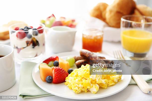 breakfast table with eggs, fruit, and sausages - continental breakfast stock pictures, royalty-free photos & images