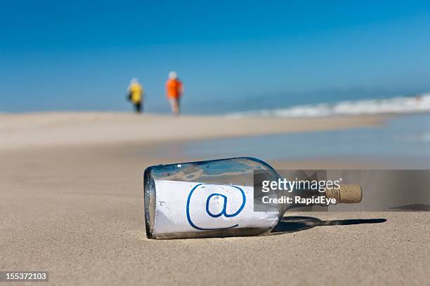 ferner beachcombers ignorieren nachricht in der flasche, "@" - flaschenpost stock-fotos und bilder