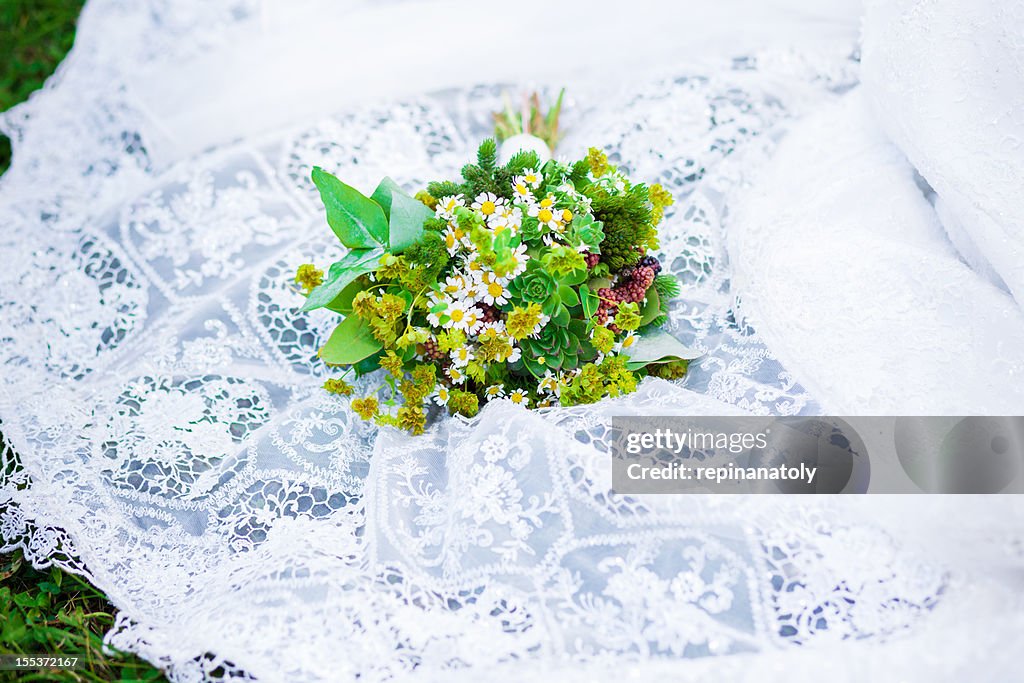 Bridal bouquet of wild flowers on the bride's dress