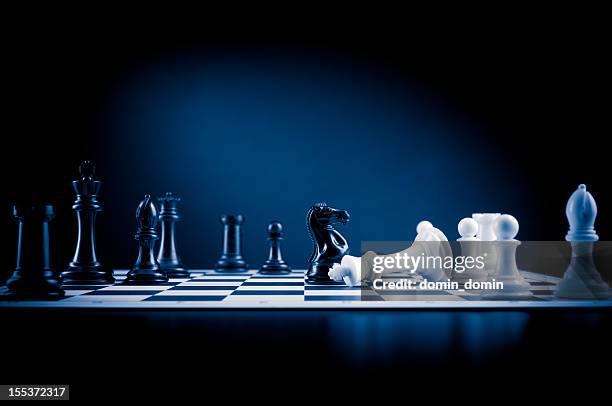 checkmate move on chessboard in blue, white king defeated - bishop chess stock pictures, royalty-free photos & images