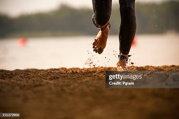 triathlete runs out of a lake - sprint triathlon stock pictures, royalty-free photos & images