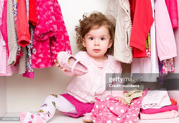 baby girl choosing her clothes - baby booties 個照片及圖片檔
