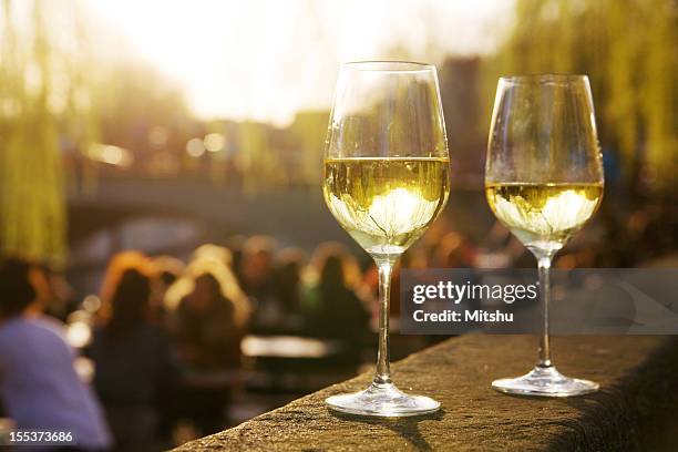 two glasses of wine in an outside cafe - chardonnay grape stock pictures, royalty-free photos & images