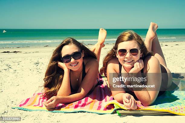 beautiful teenagers sunbathing on the beach. - girls sunbathing stock pictures, royalty-free photos & images