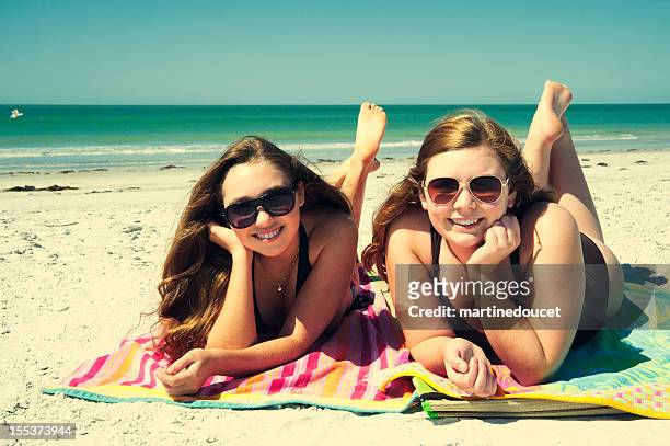 beautiful teenagers sunbathing on the beach. - girls sunbathing 個照片及圖片檔