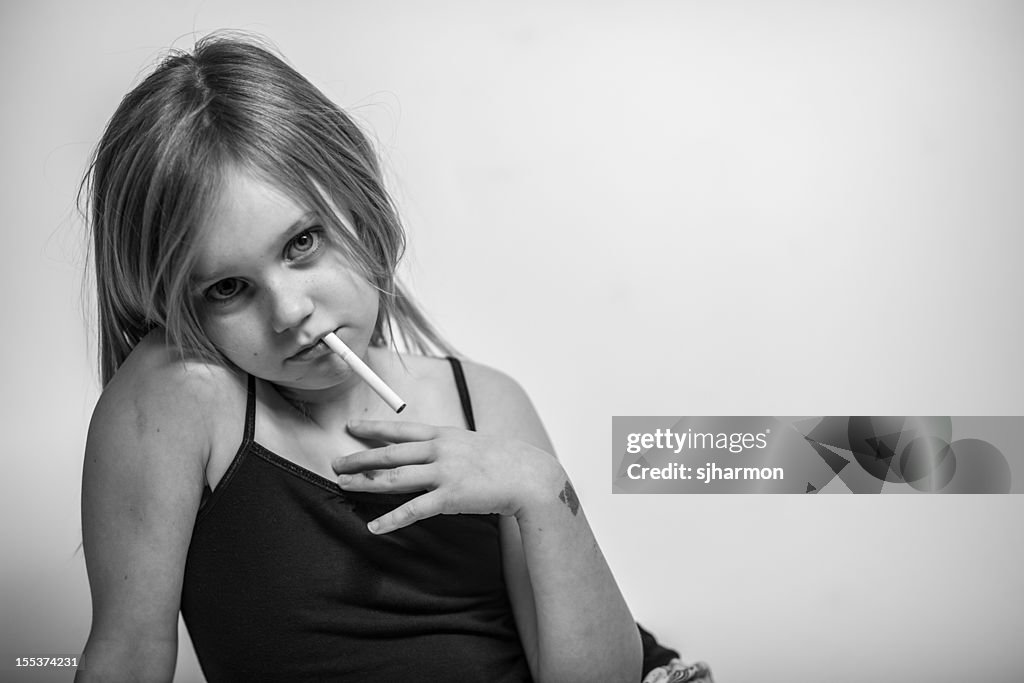 Porträt der jungen Frau mit Zigarette im Mund, Blick in die Kamera