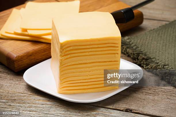 Tall Stack Of Orange Cheese On White Plate High-Res Stock Photo