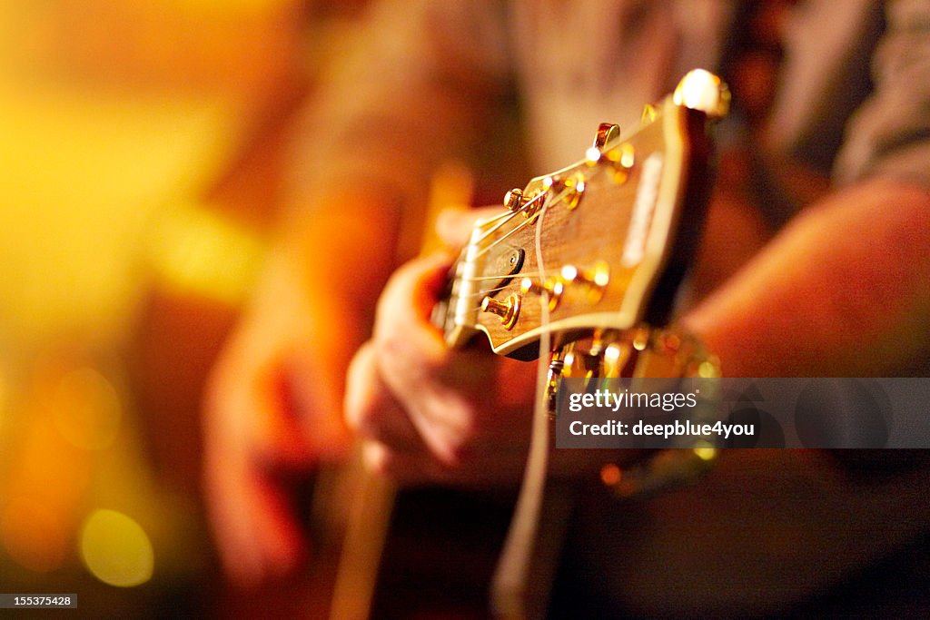 Young man playing acoustic guitar in concert