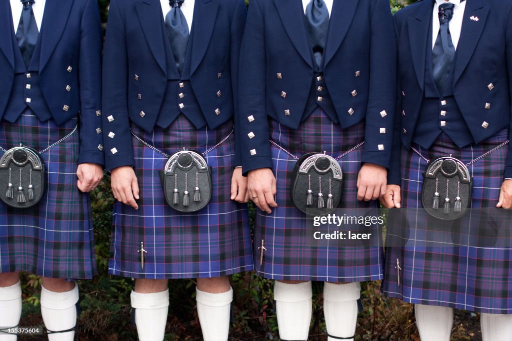 Line of men wearing purple kilts